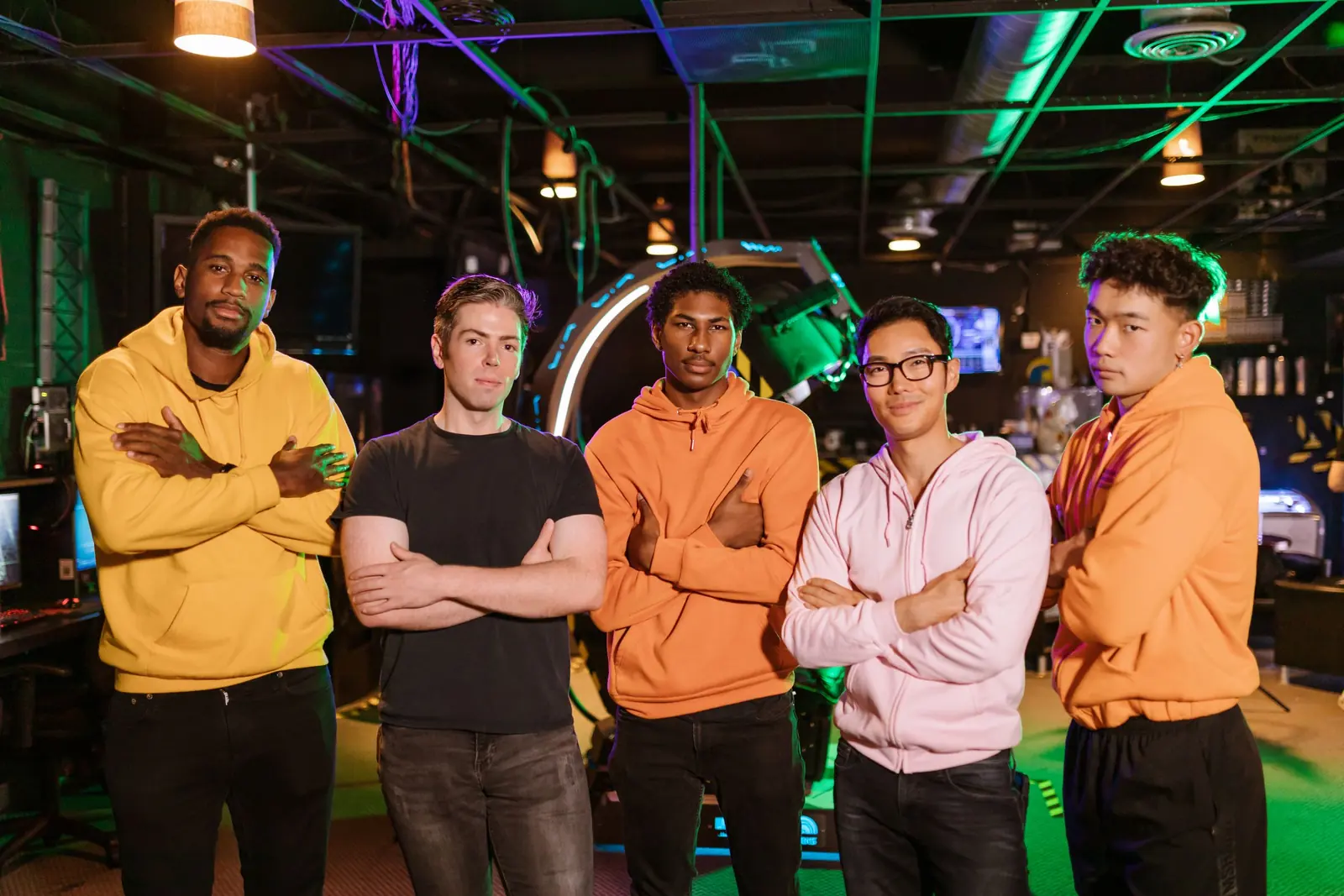 A crew of five friends posing together inside the gaming lounge